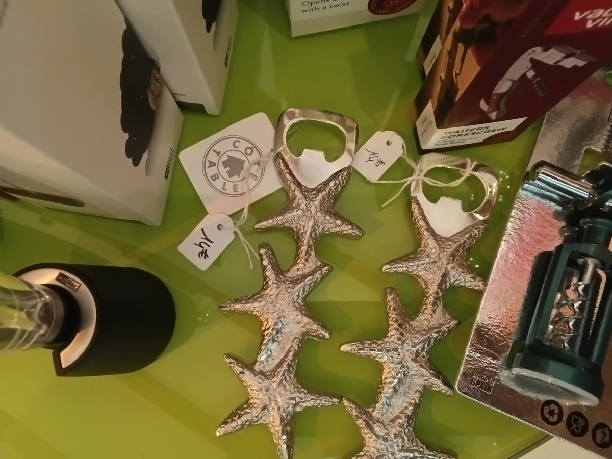 Des capsuleurs étoiles de mer argent cote table