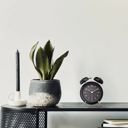 Réveil Golden Hour noir NeXtime posé sur table de nuit intérieur élégant