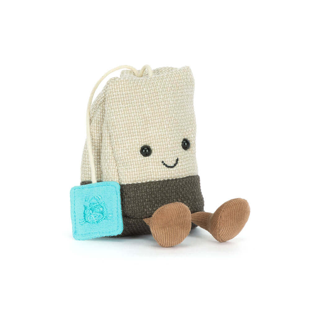 Peluche sachet de thé bicolore Jellycat avec étiquette bleue, petit sourire et jambes en velours marron.