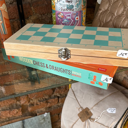 Boîte en bois fermée avec les pièces d'échecs et les pions rangés à l'intérieur.