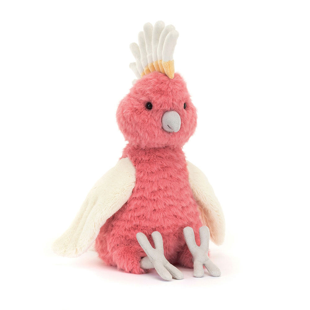 Peluche cacatoès rose Squawkatoo Jellycat assise avec crête jaune et ailes crème.