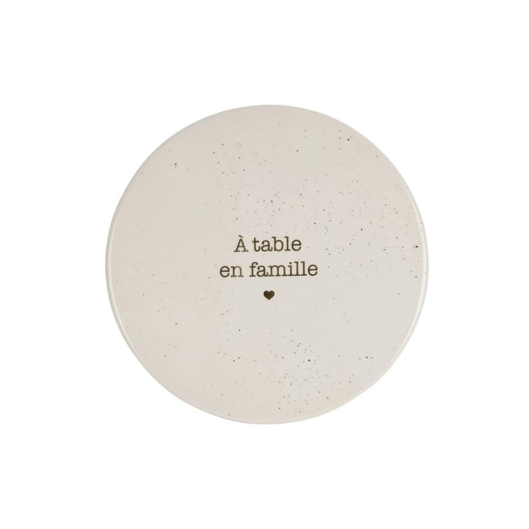Dessous de plat rond en grès blanc moucheté avec l'inscription À table en famille et un petit cœur, marque SEMA Design.