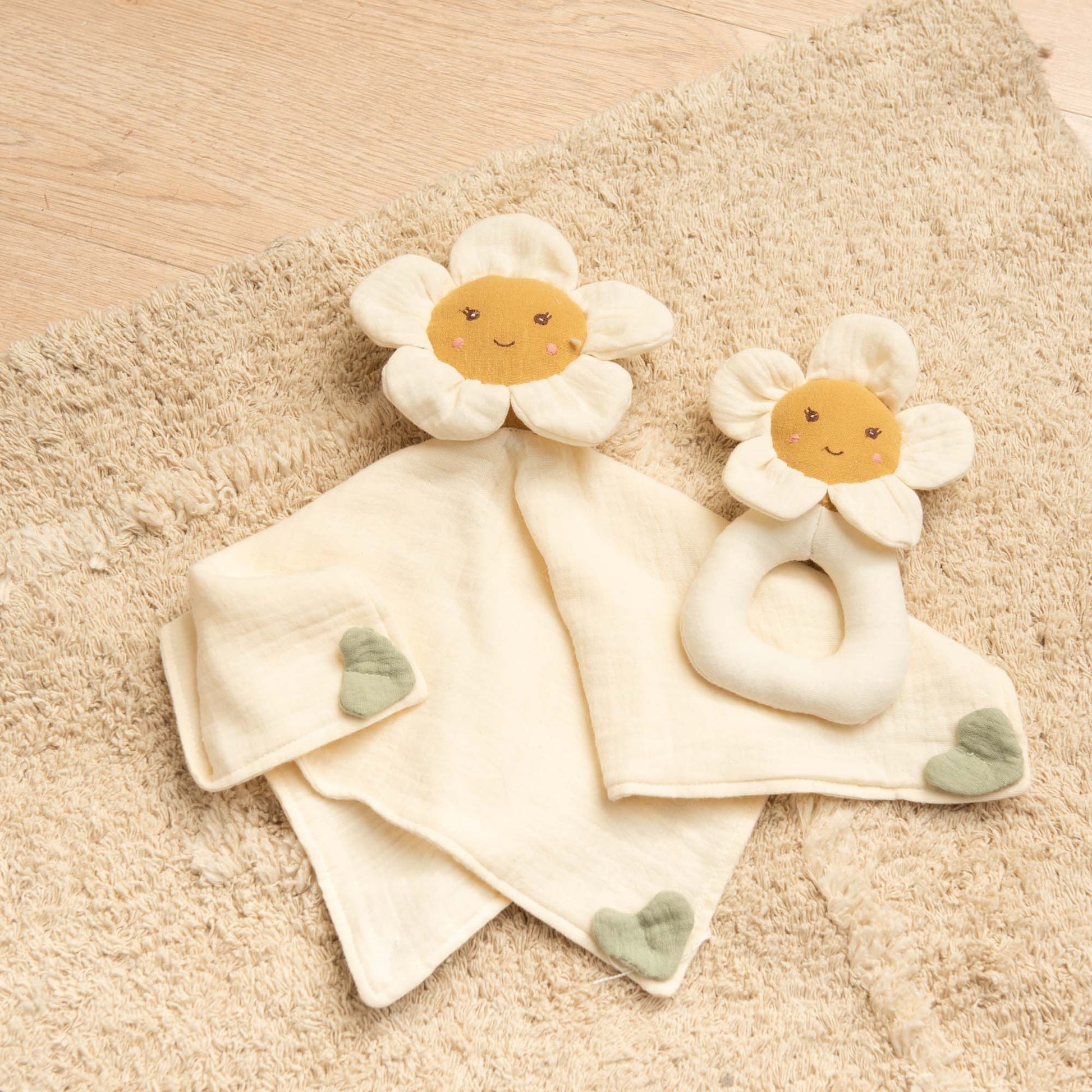 Doudou plat marguerite posé dans lit bébé compagnon nuit doux et sécurisé