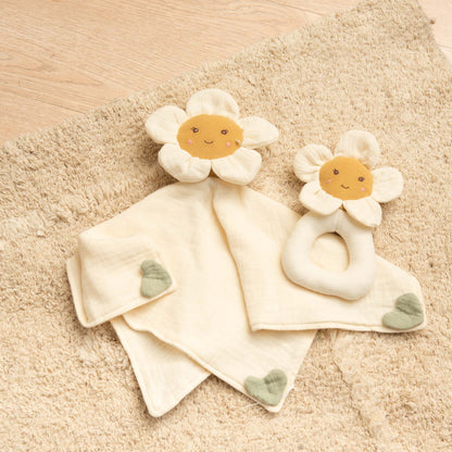 Doudou plat marguerite posé dans lit bébé compagnon nuit doux et sécurisé