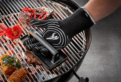 Manipulation d'une grille de barbecue chaude avec le gant de protection haute température